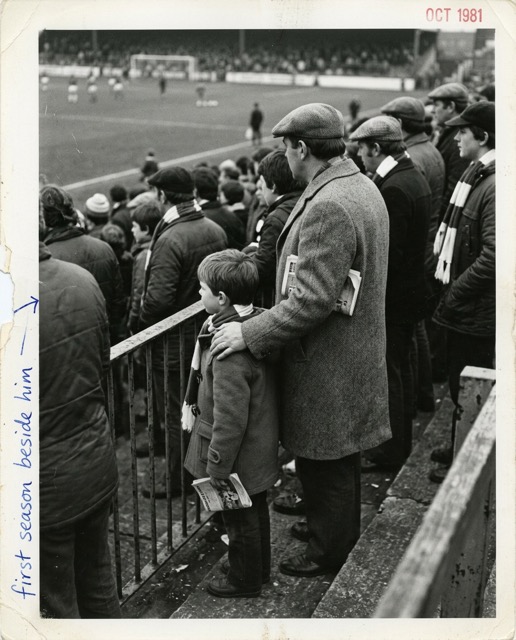 A father and son sharing the same place in the stand